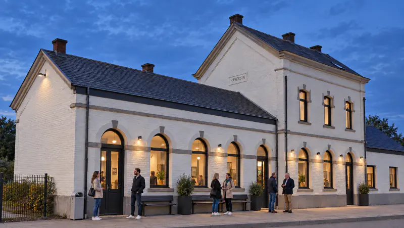 La gare d’Haversin accueillante et éclairée, avec des invités devant la façade.