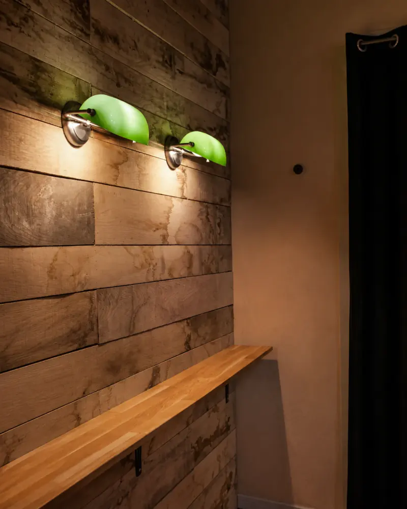 Deux appliques en verre vert sur le bois du bar